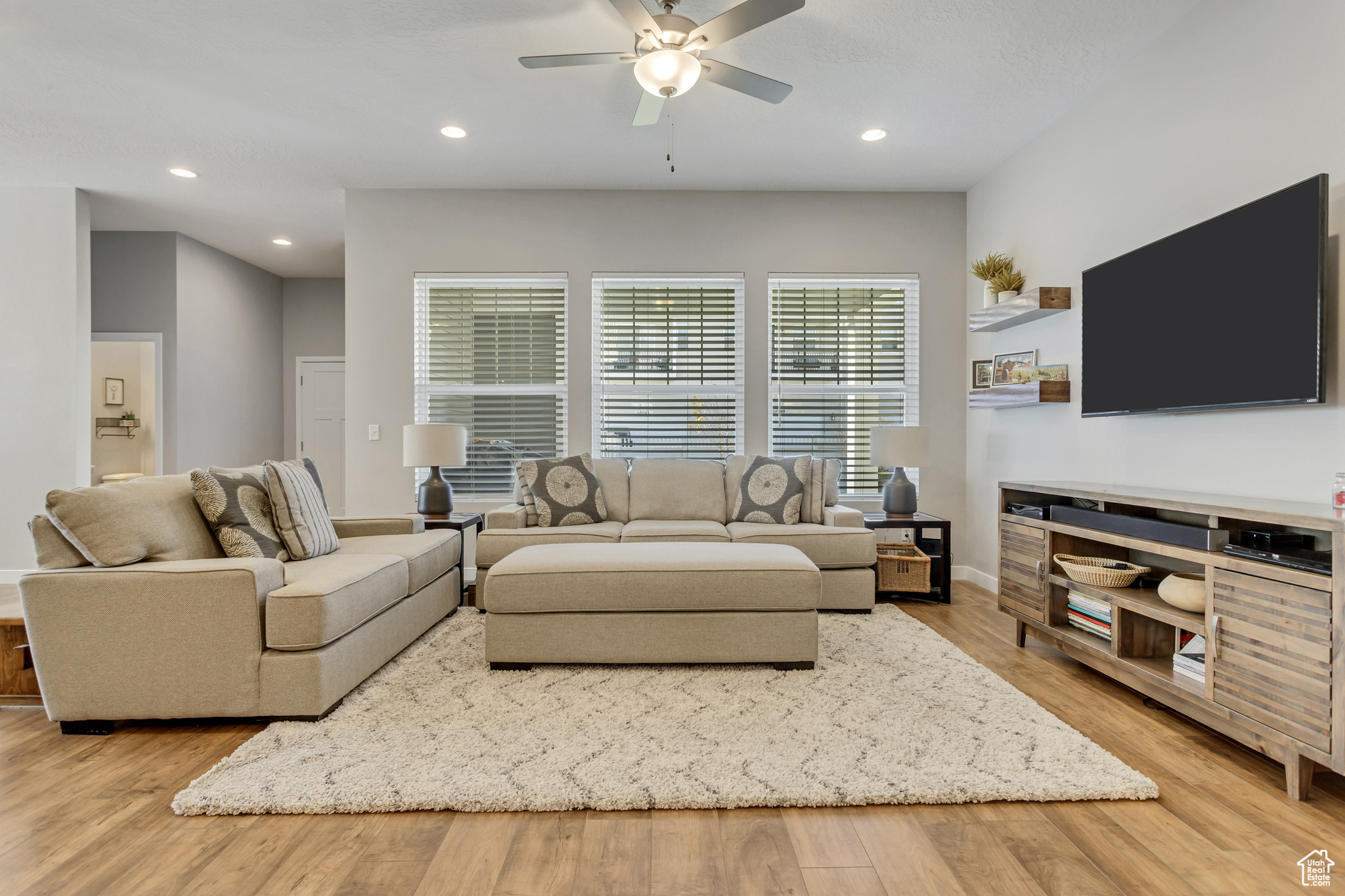 Living room with ceiling fan and light hardwood / wood-style flooring