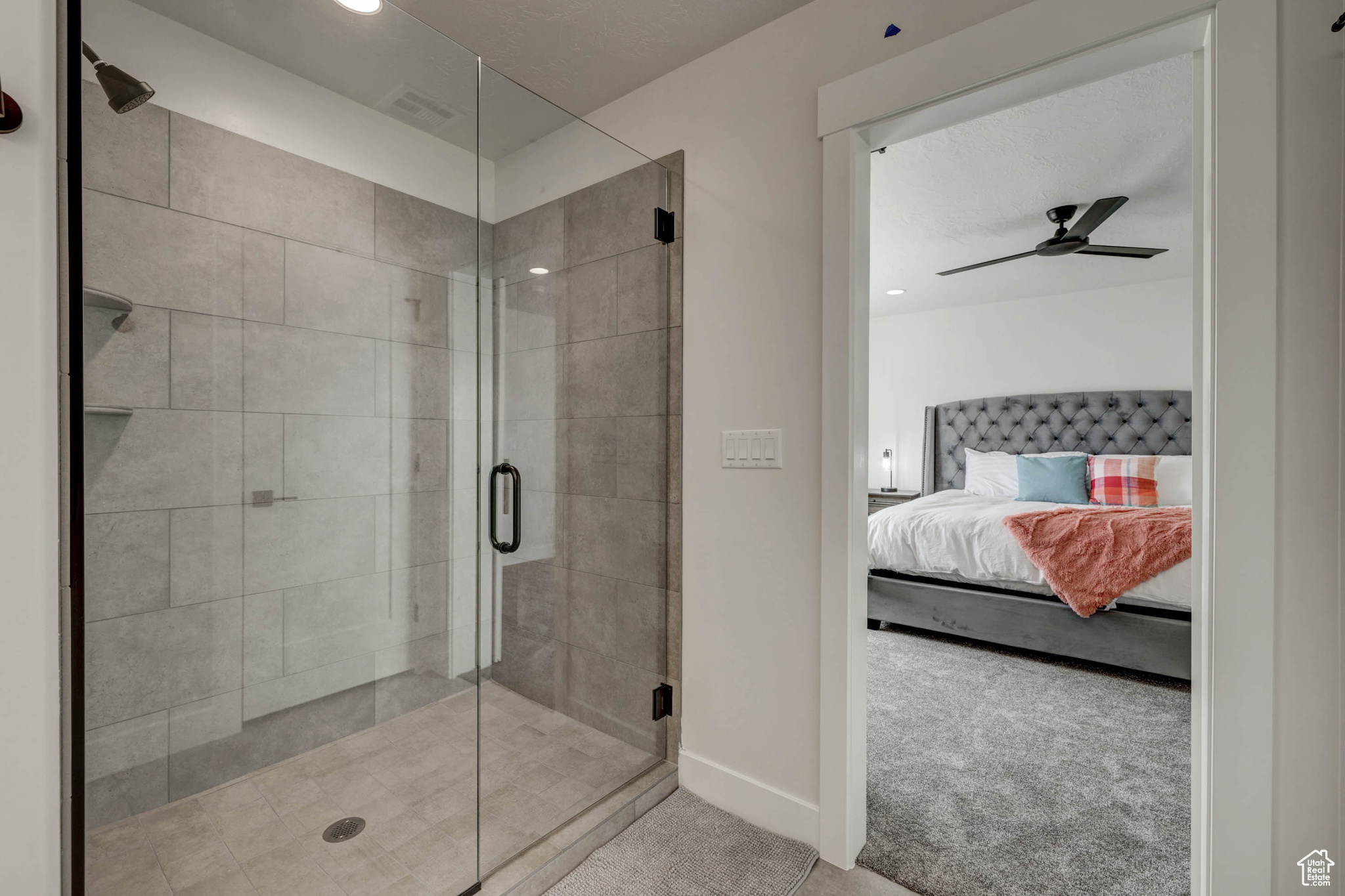 Bathroom with ceiling fan and a shower with shower door