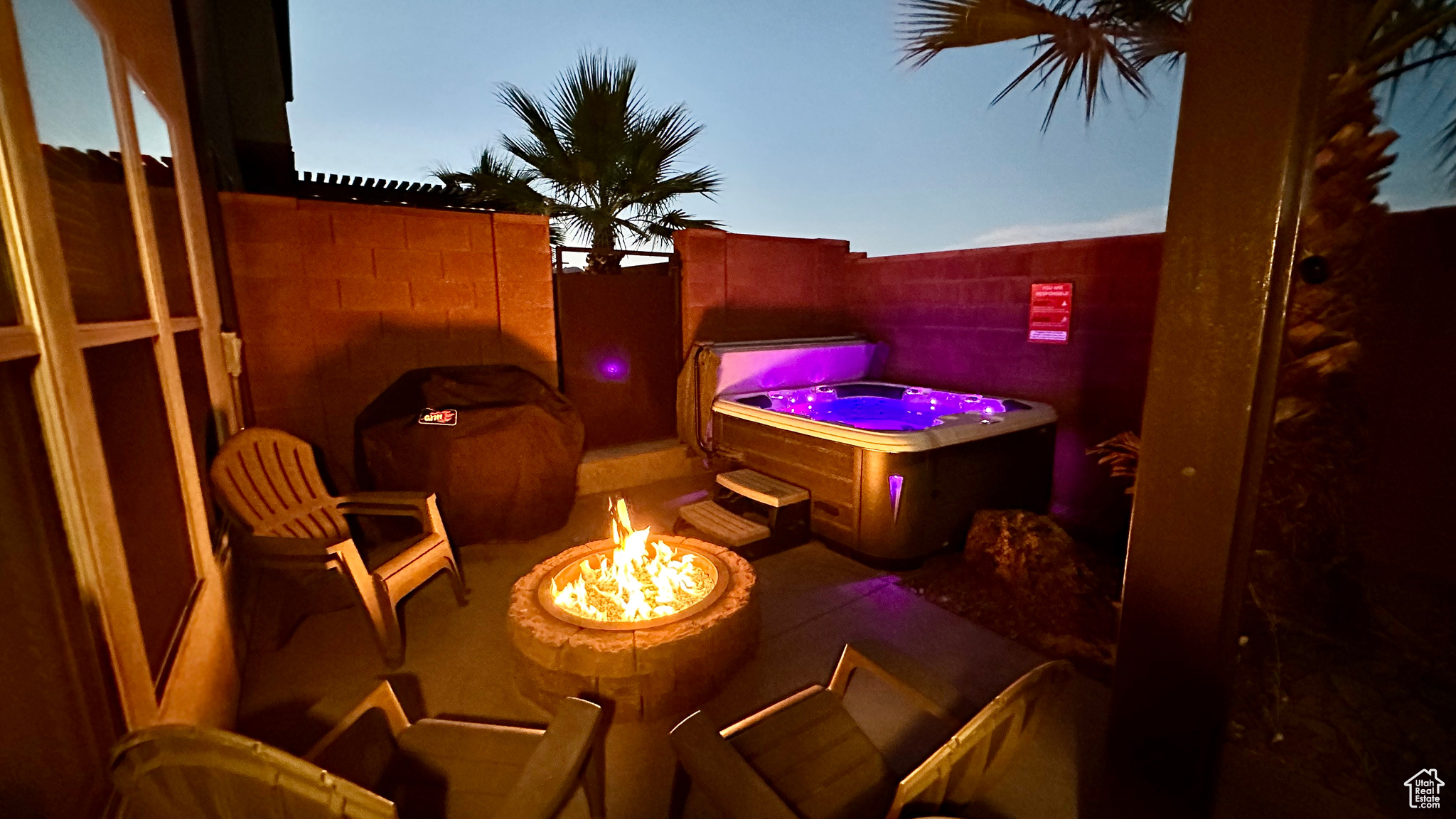 View of patio with a grill, a hot tub, and an outdoor fire pit