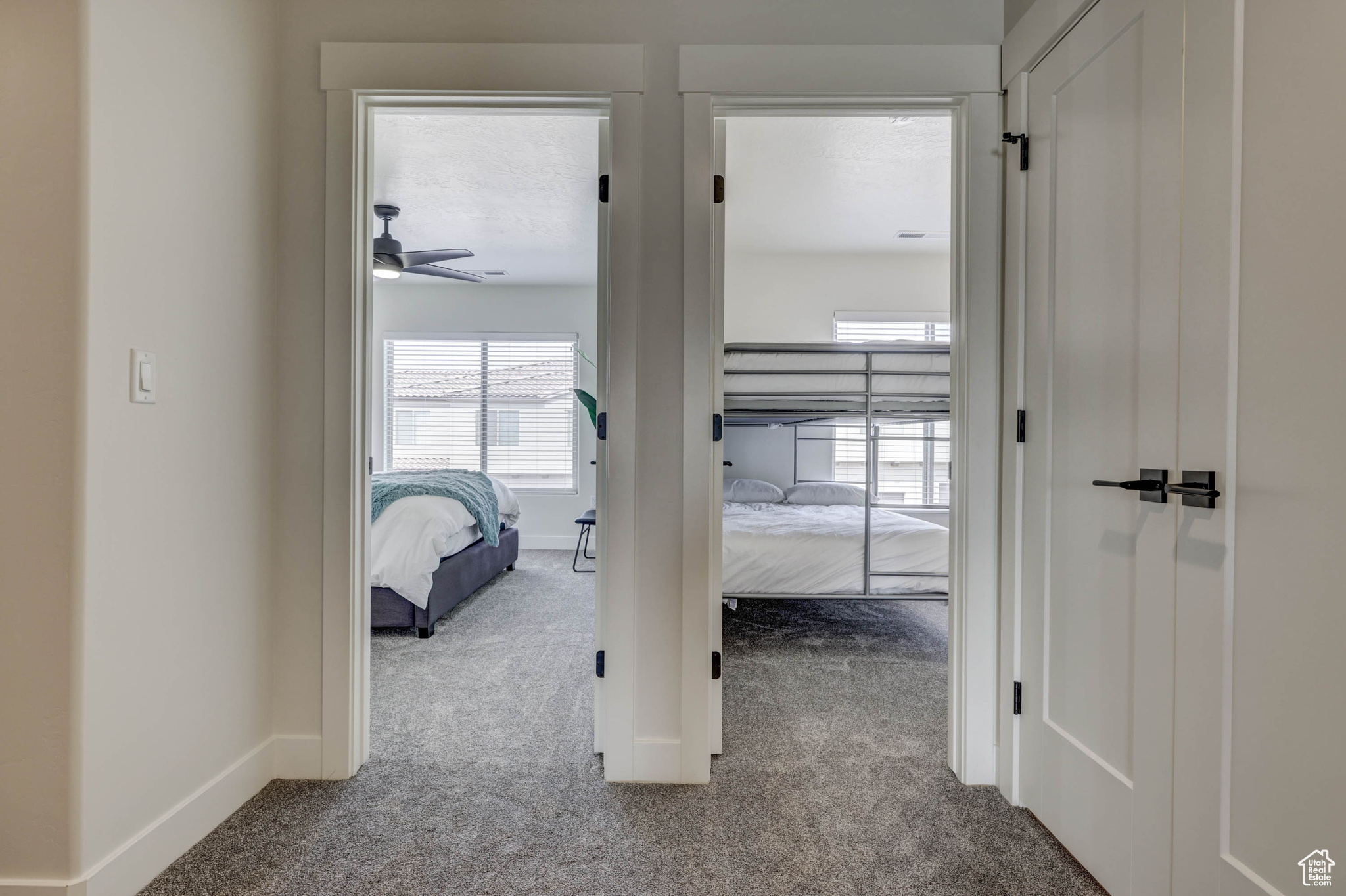 Hallway featuring light colored carpet