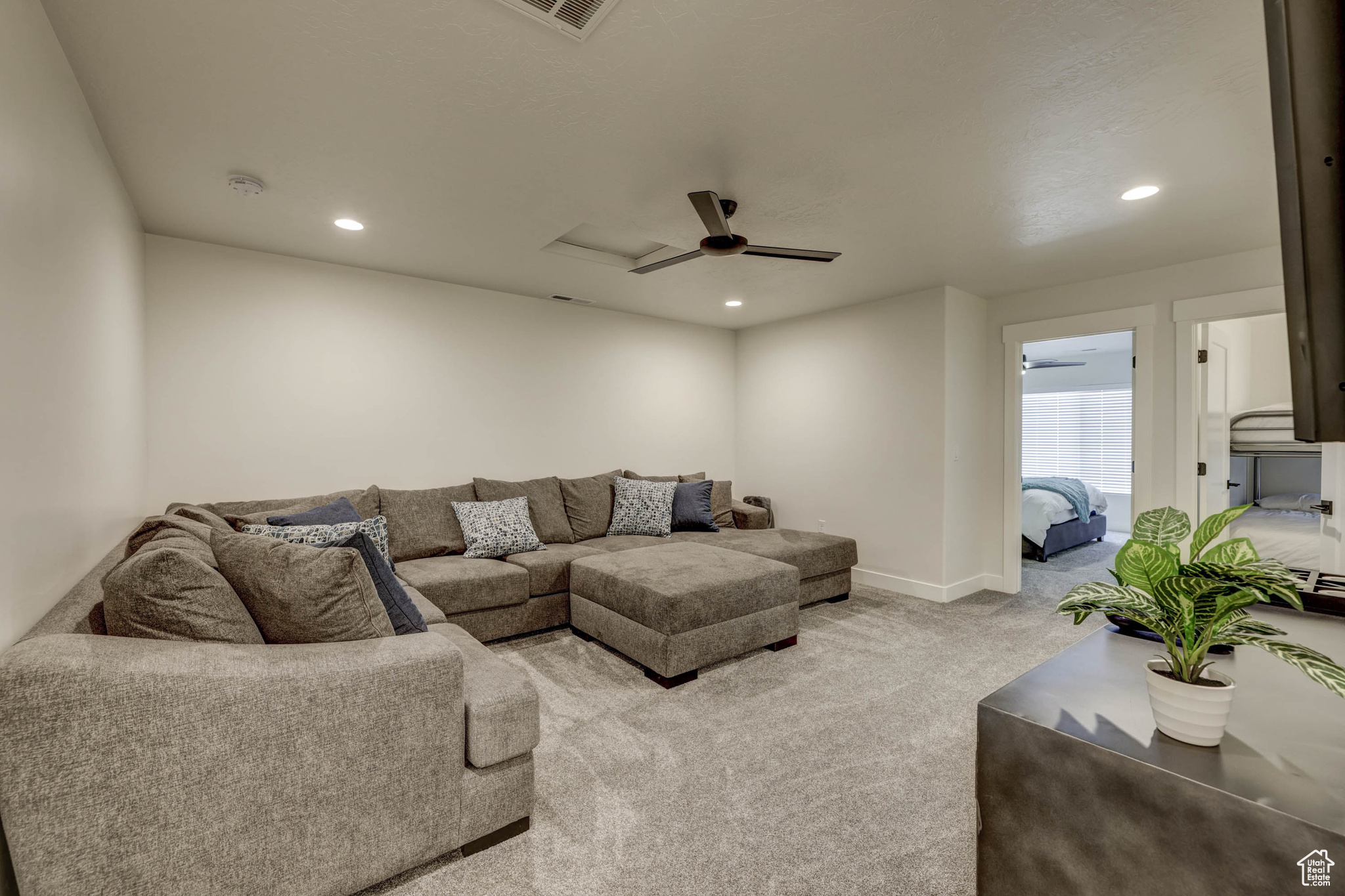 Carpeted living room with ceiling fan