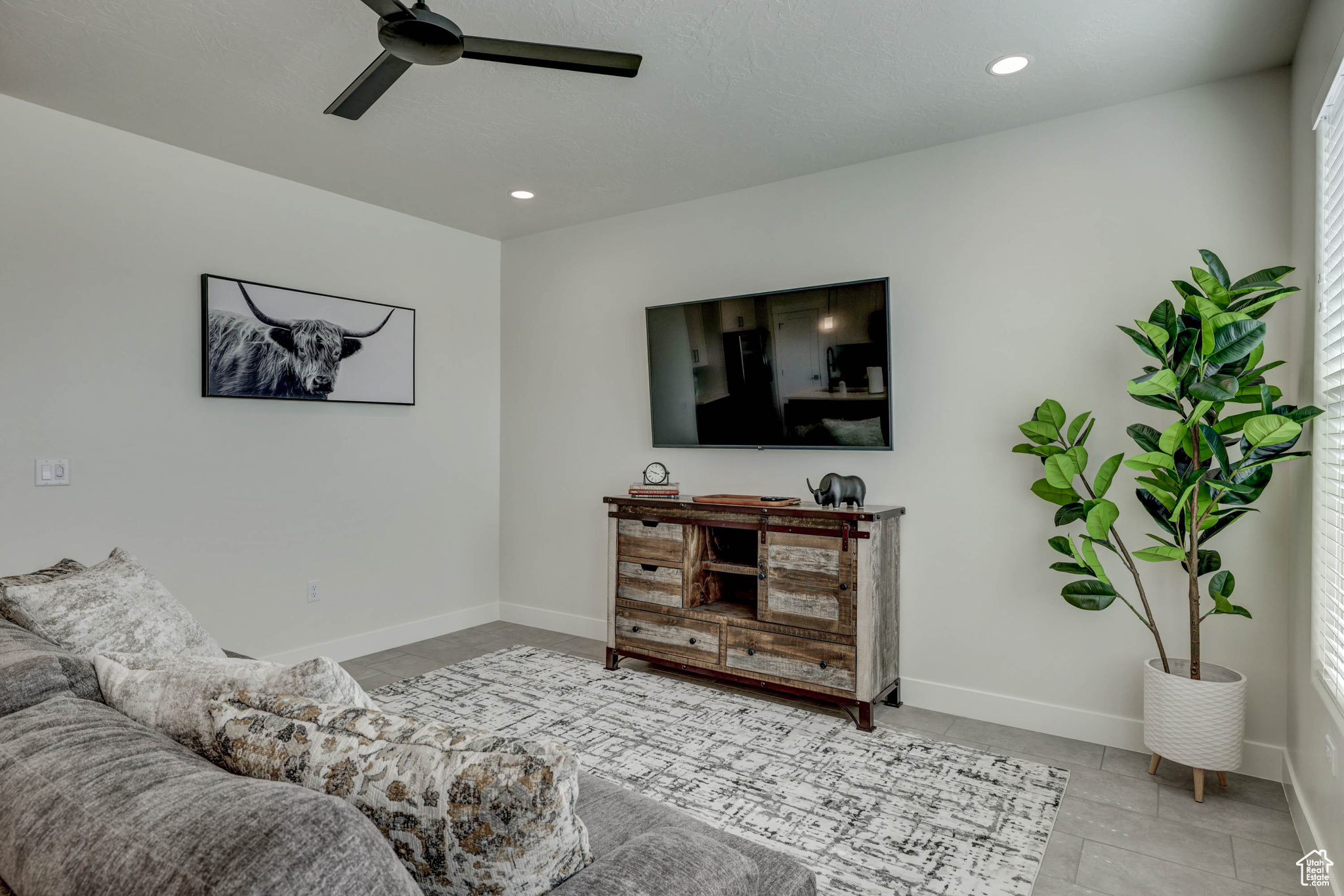 Tiled living room featuring ceiling fan