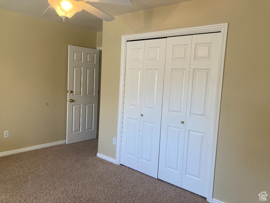 Third upstairs bedroom featuring a closet, ceiling fan, and carpet