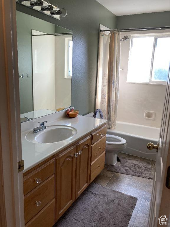 Full bathroom with shower / bathtub combination with curtain, toilet, tile flooring, and vanity