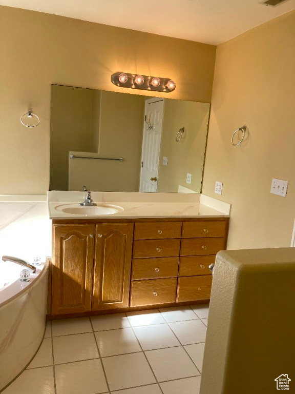 Primary bathroom with a deep tub, tile floors, and vanity