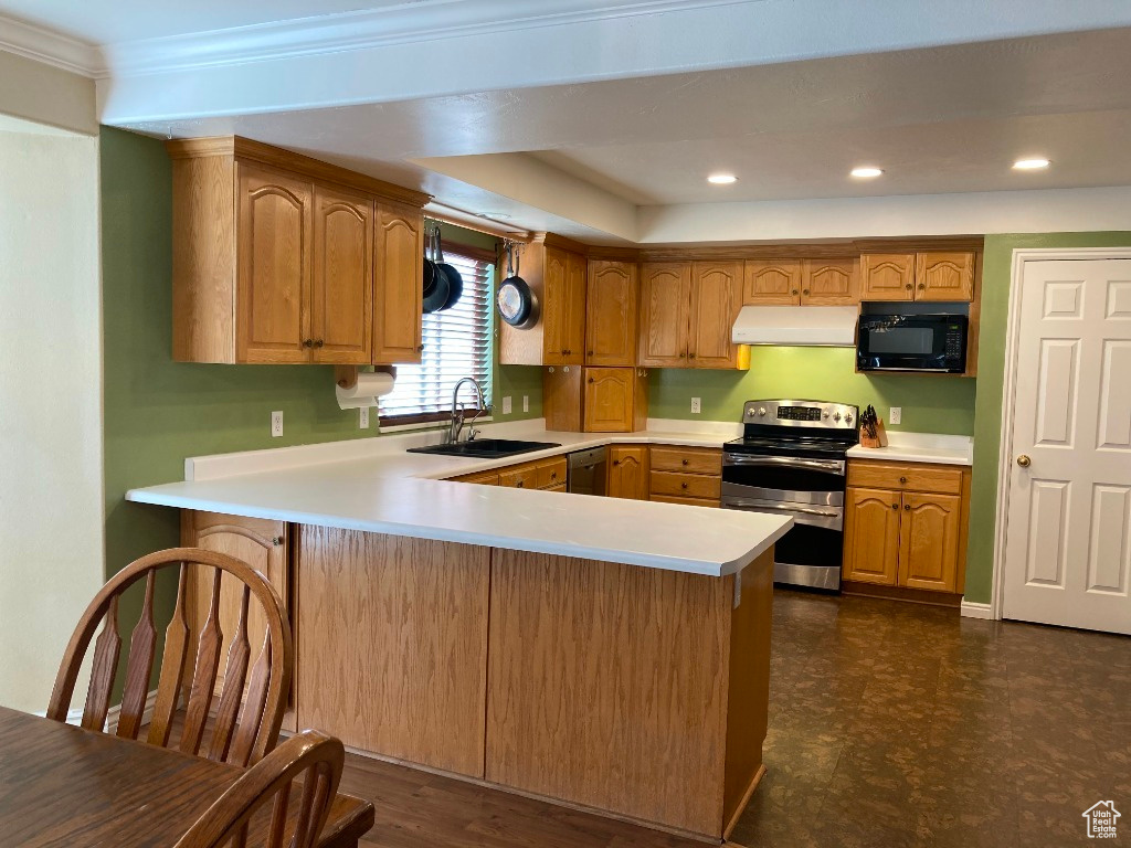 Kitchen with sink, appliances with stainless steel finishes, large peninsula, and crown molding