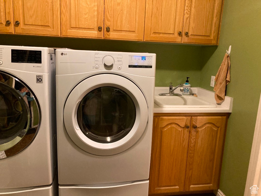 Laundry room with cabinets, sink, and washer and dryer