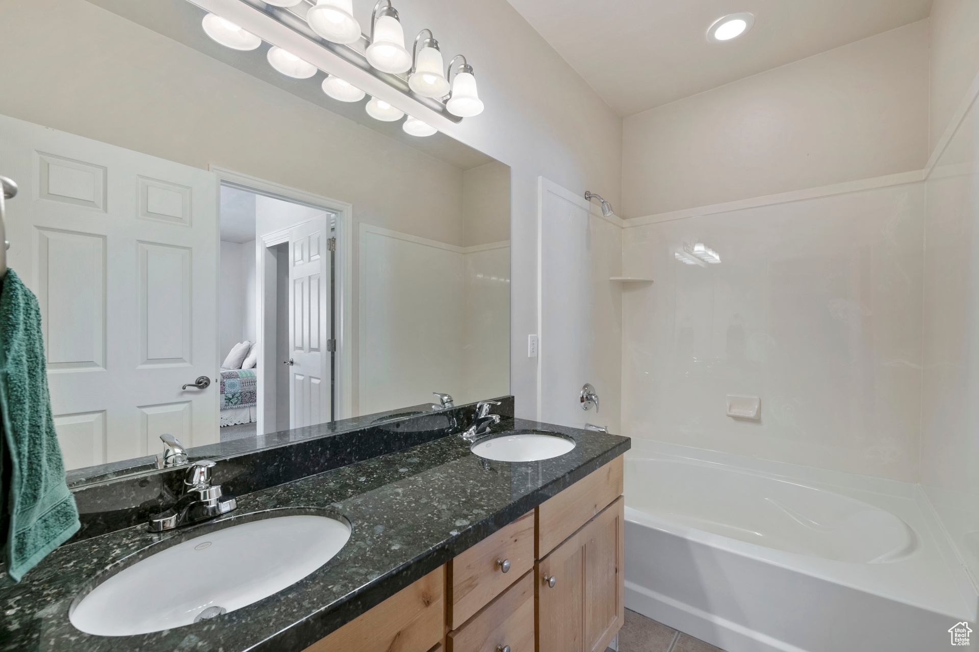 Primary suite with granite and double sink vanity.