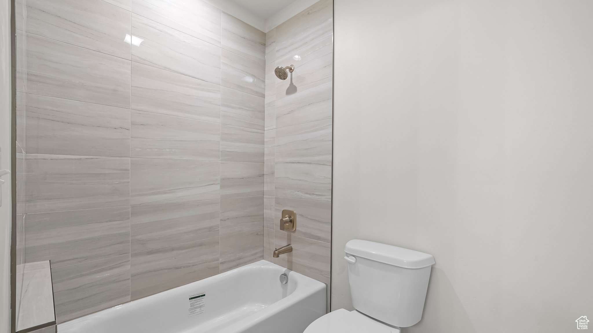 Bathroom featuring tiled shower / bath and toilet