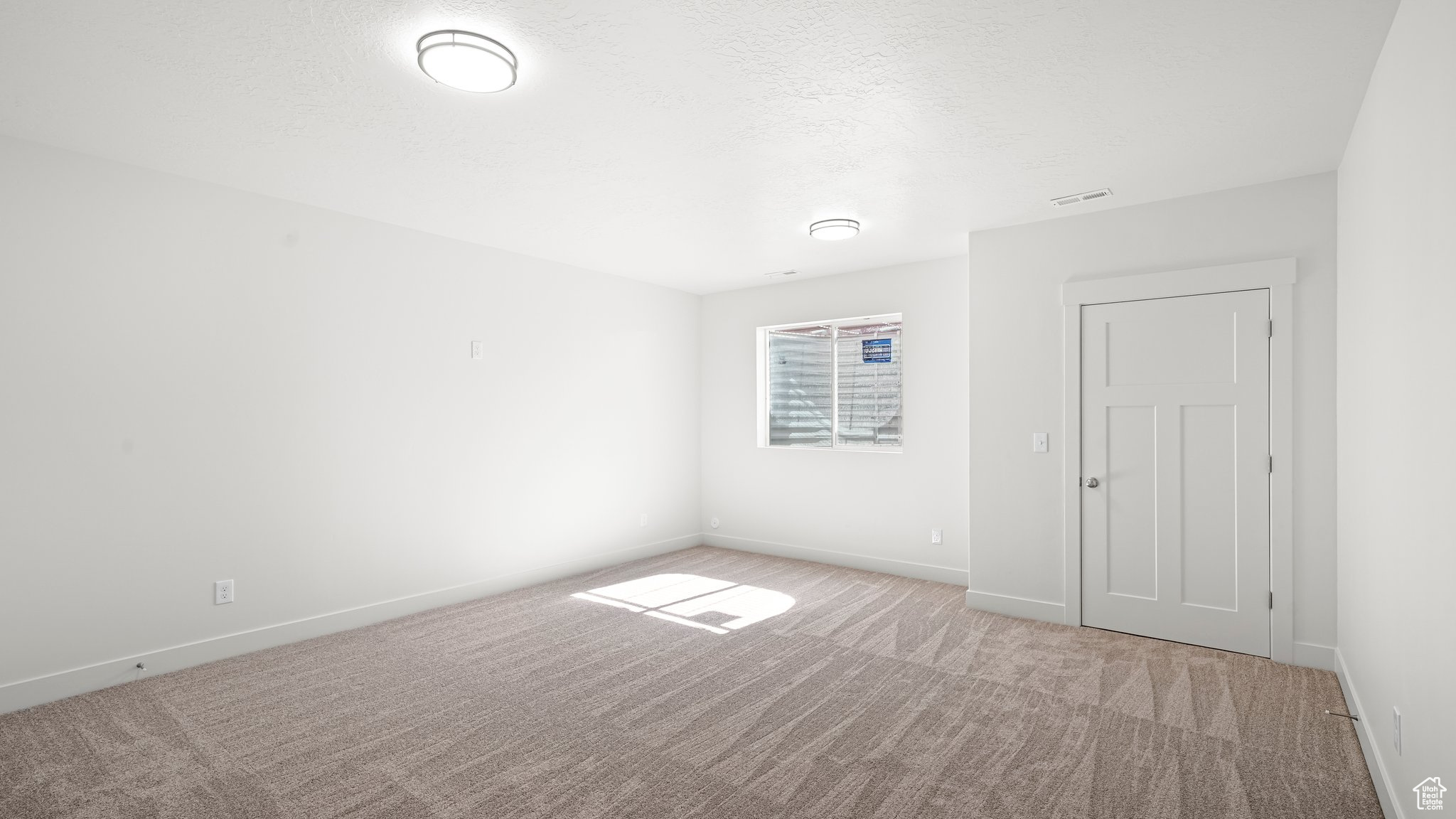 Unfurnished room featuring light carpet