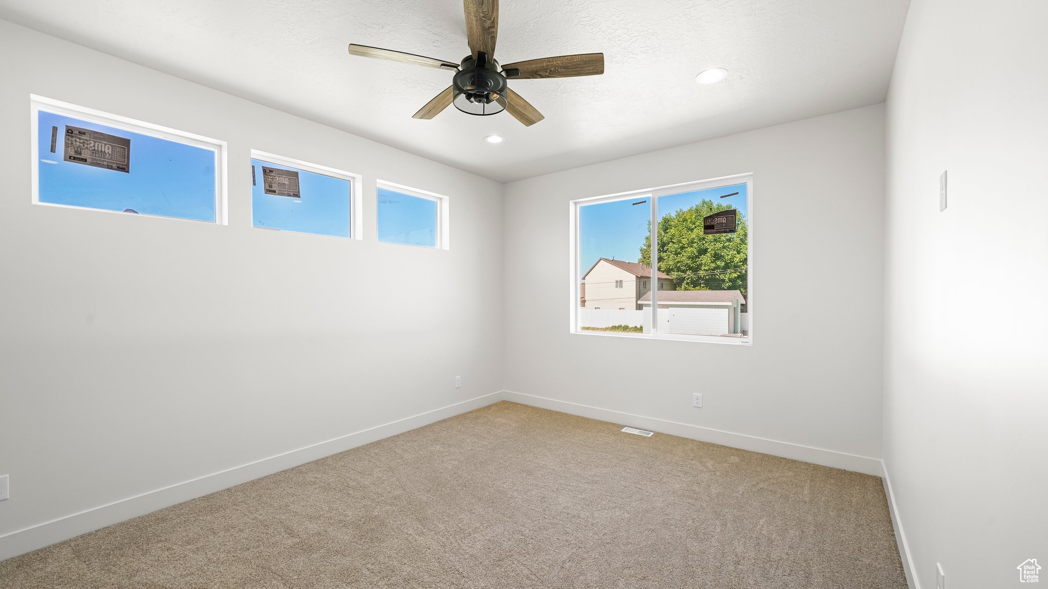 Carpeted room with ceiling fan