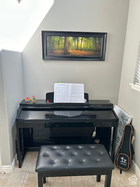 Piano nook with vaulted ceiling and light tile floors