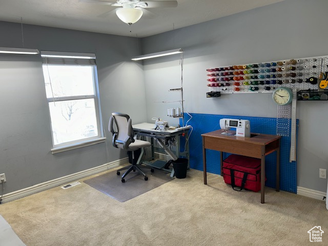 Office/bedroom/sewing room featuring light colored carpet and ceiling fan