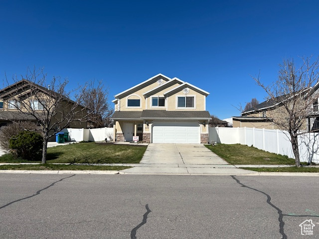 View of property with a garage and a front yard