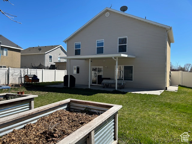 Back of property featuring a lawn and a patio