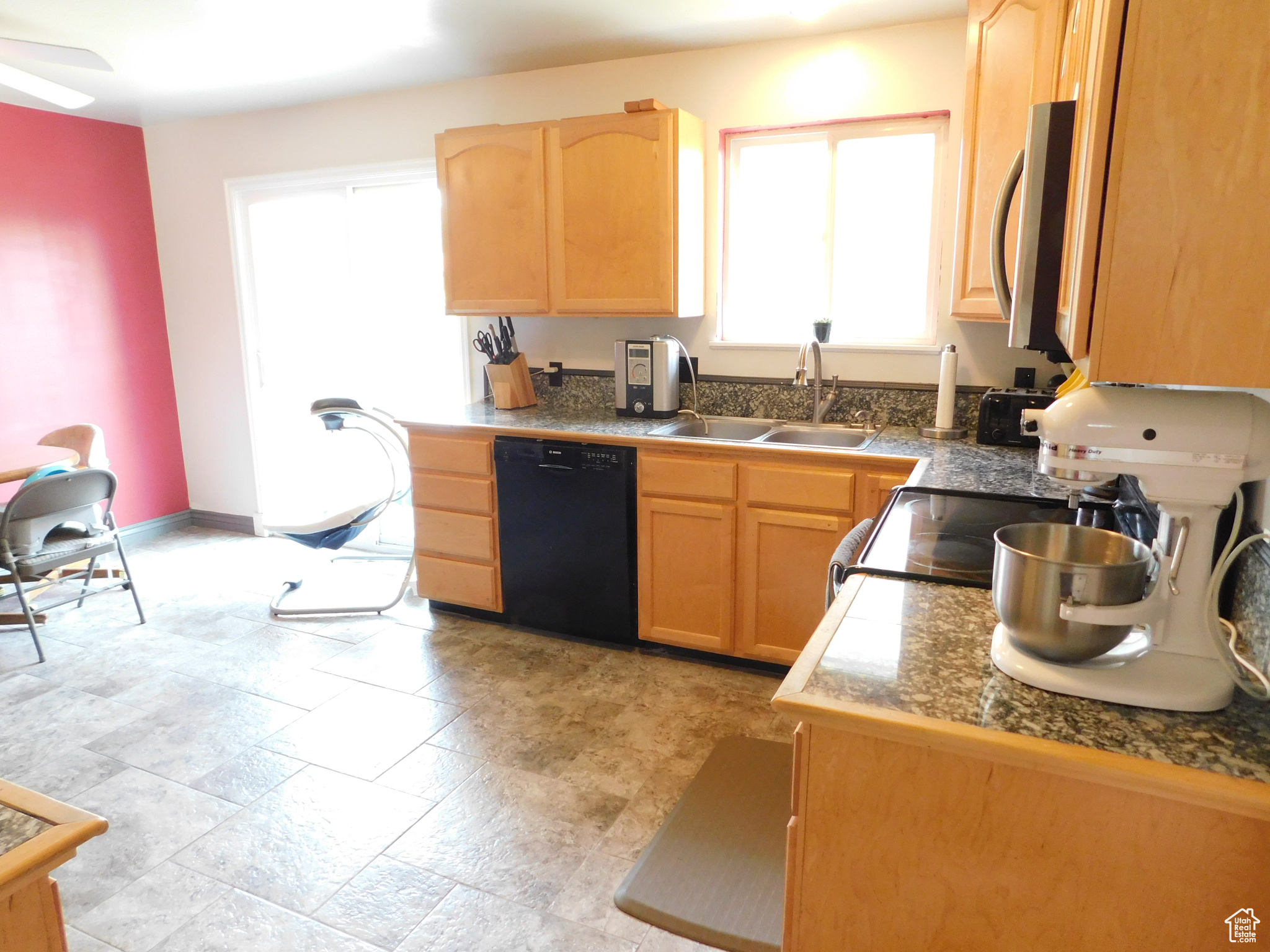 Kitchen with ceiling fan, range, sink, dishwasher, and light tile flooring