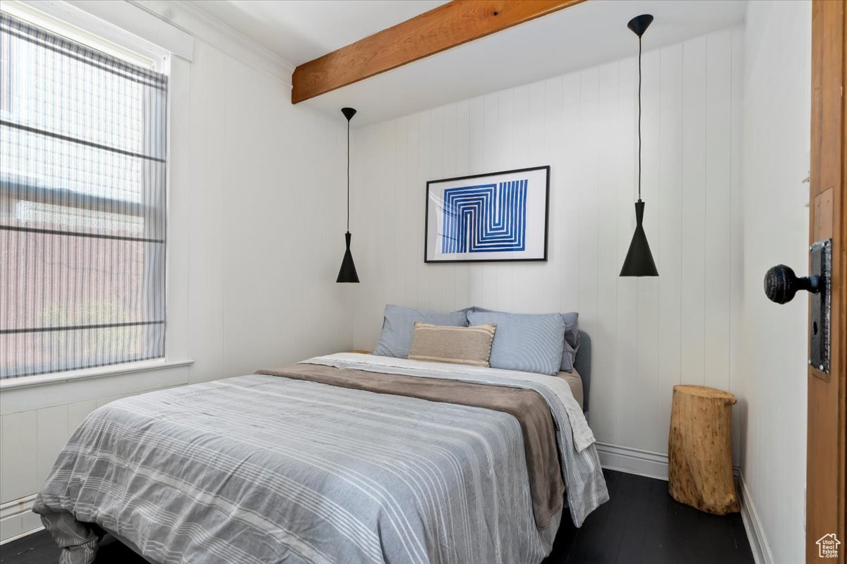 Bedroom featuring beamed ceiling and dark hardwood / wood-style flooring