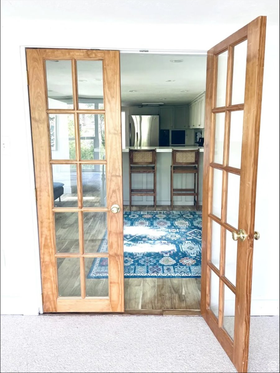 Doorway featuring light colored carpet and french doors