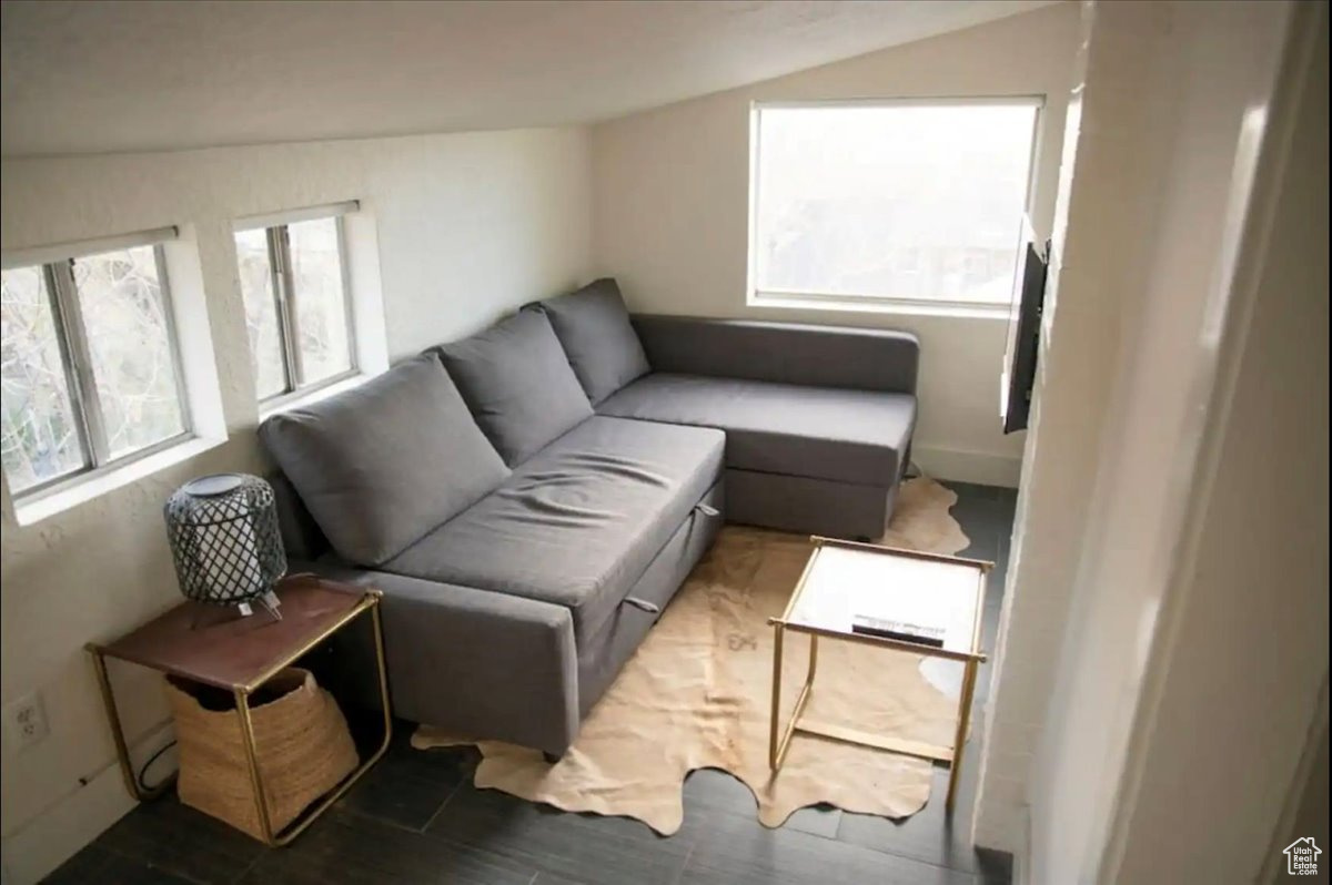 Living room with dark hardwood / wood-style floors and lofted ceiling