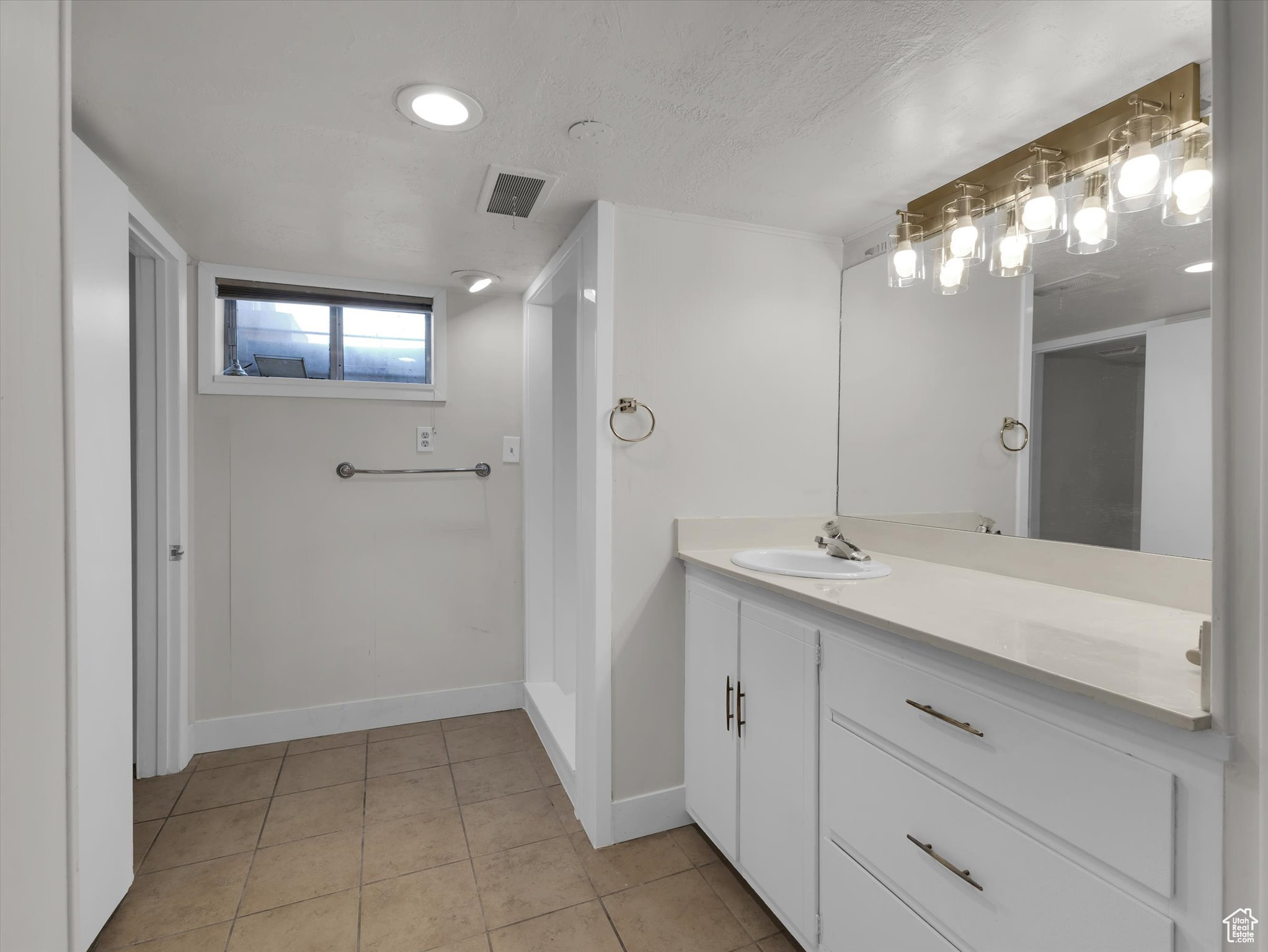 Bathroom featuring tile floors, a textured ceiling, and vanity