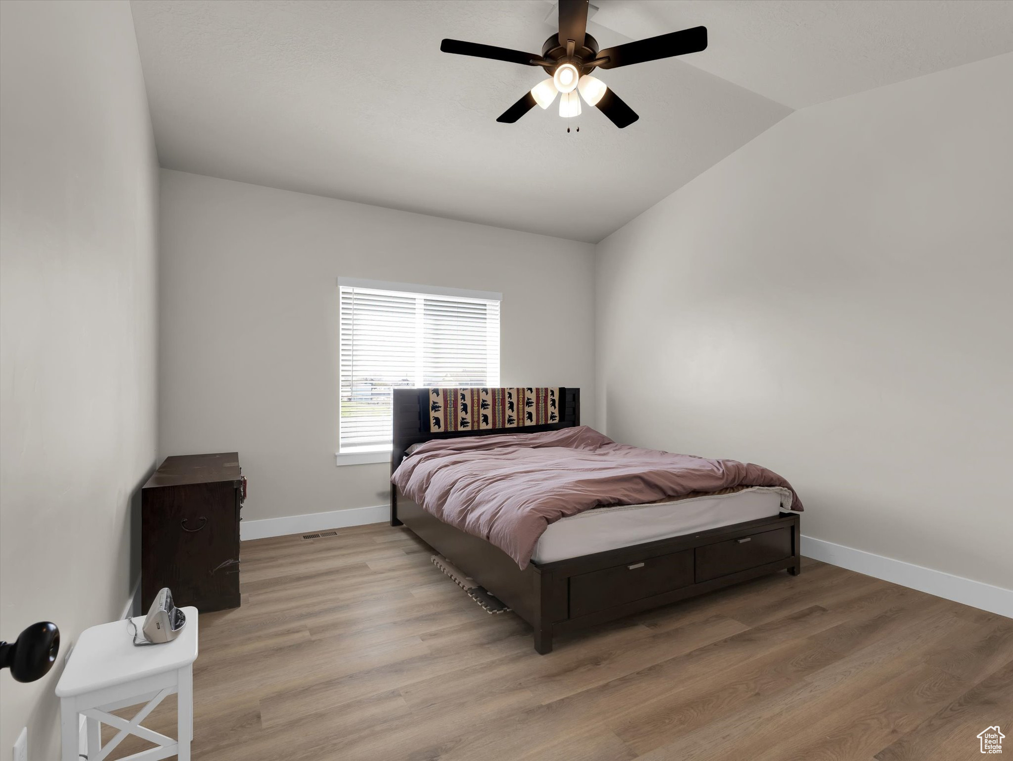Bedroom with light hardwood / wood-style flooring, ceiling fan, and lofted ceiling