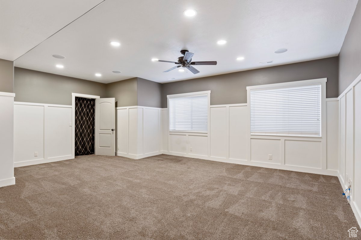 Unfurnished room with ceiling fan and light carpet