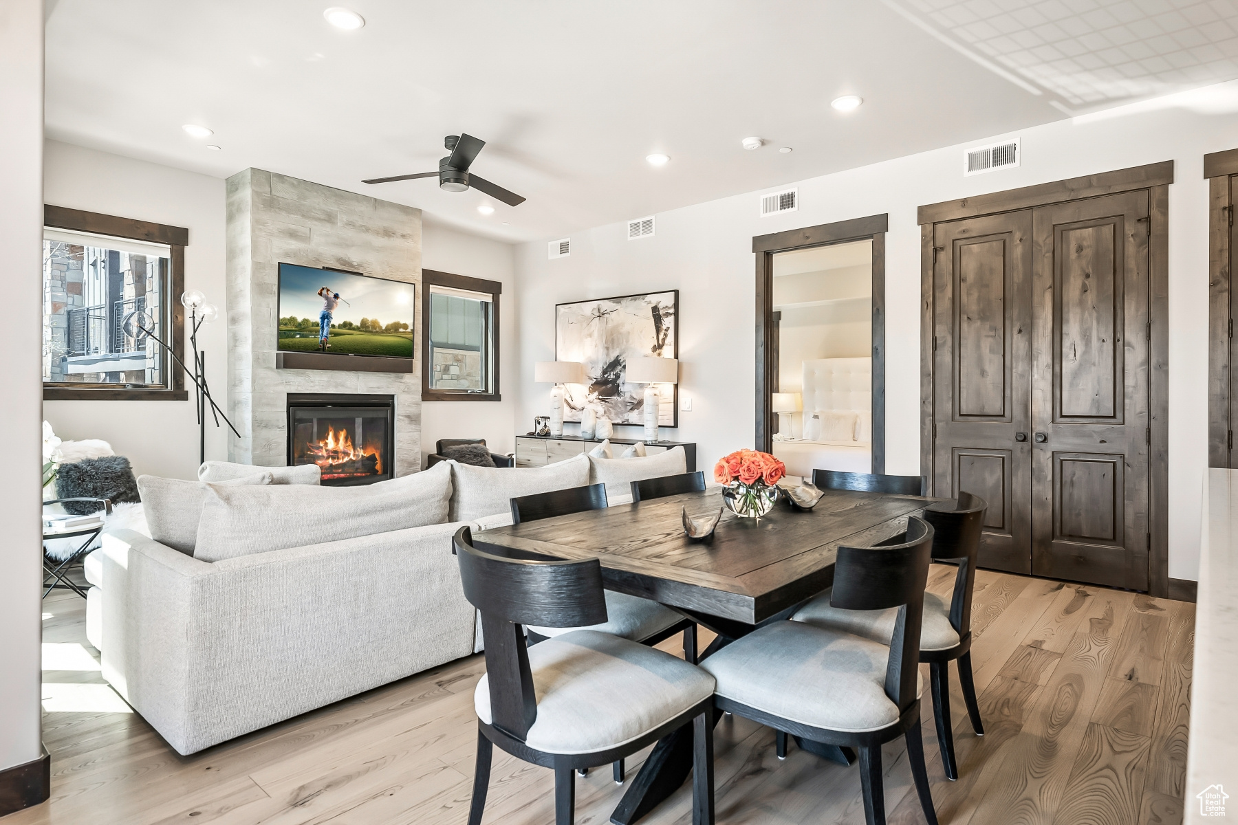 Dining space featuring light hardwood / wood-style flooring, ceiling fan, and a fireplace