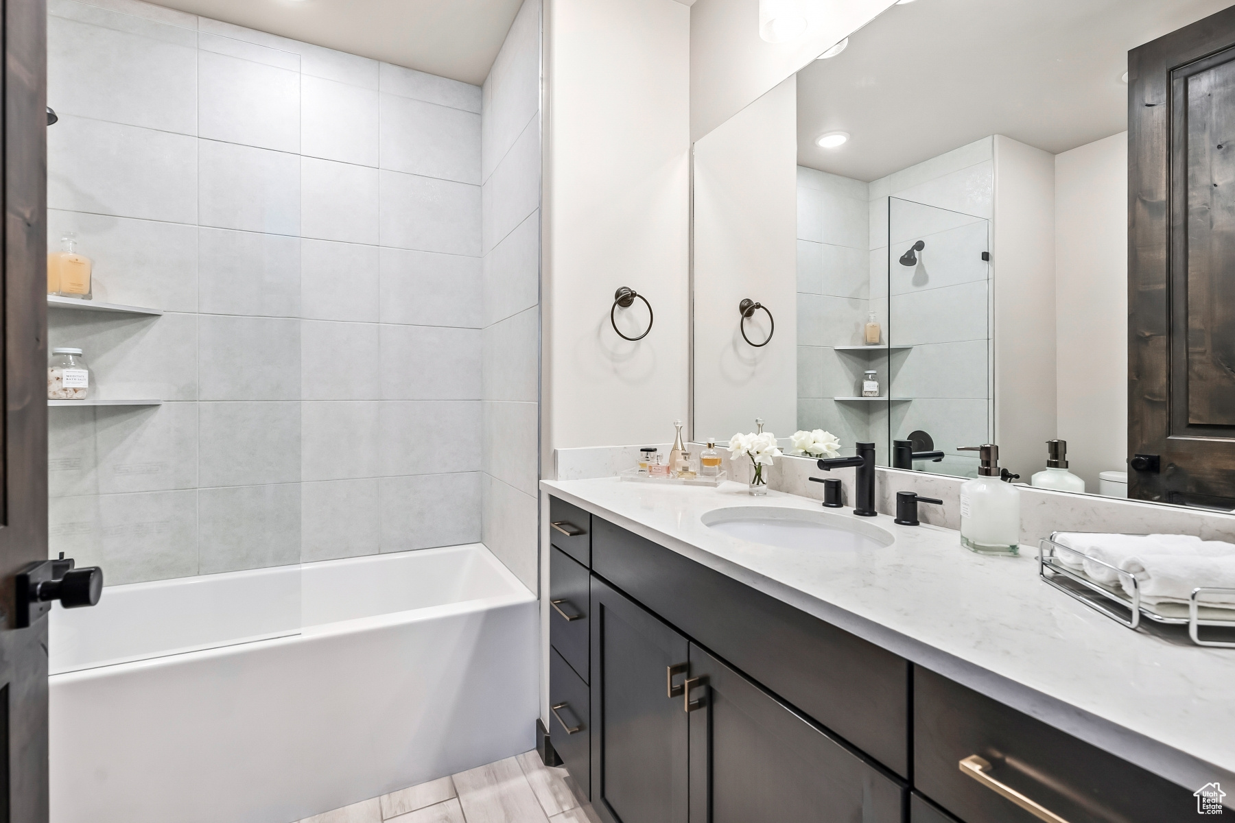 Bathroom featuring tile flooring, tiled shower / bath, and large vanity
