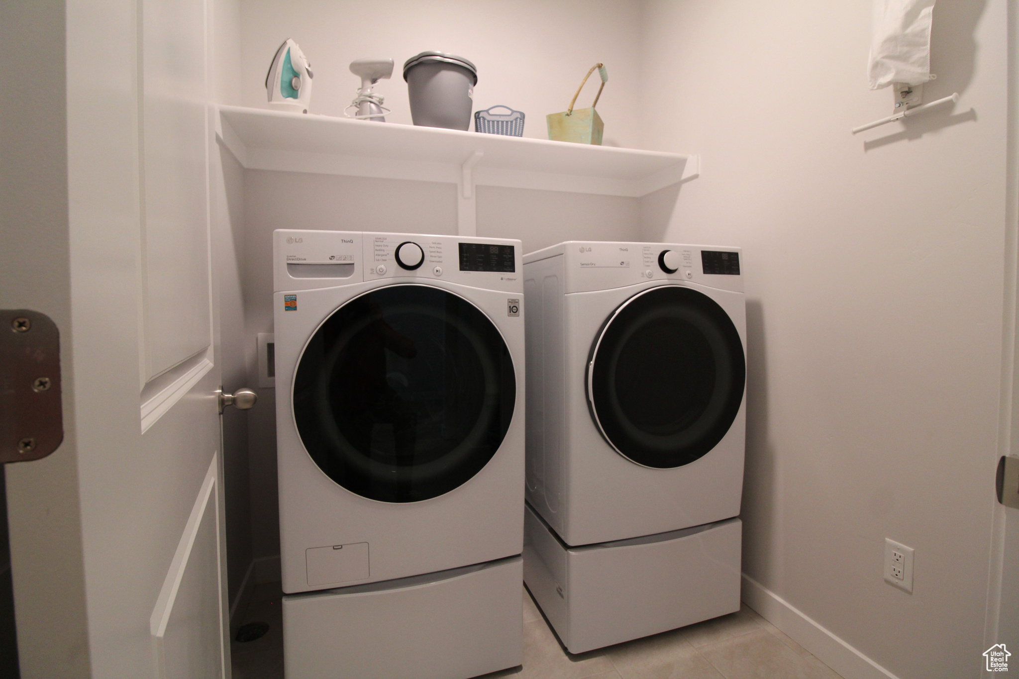 Laundry area featuring separate washer and dryer and light tile flooring