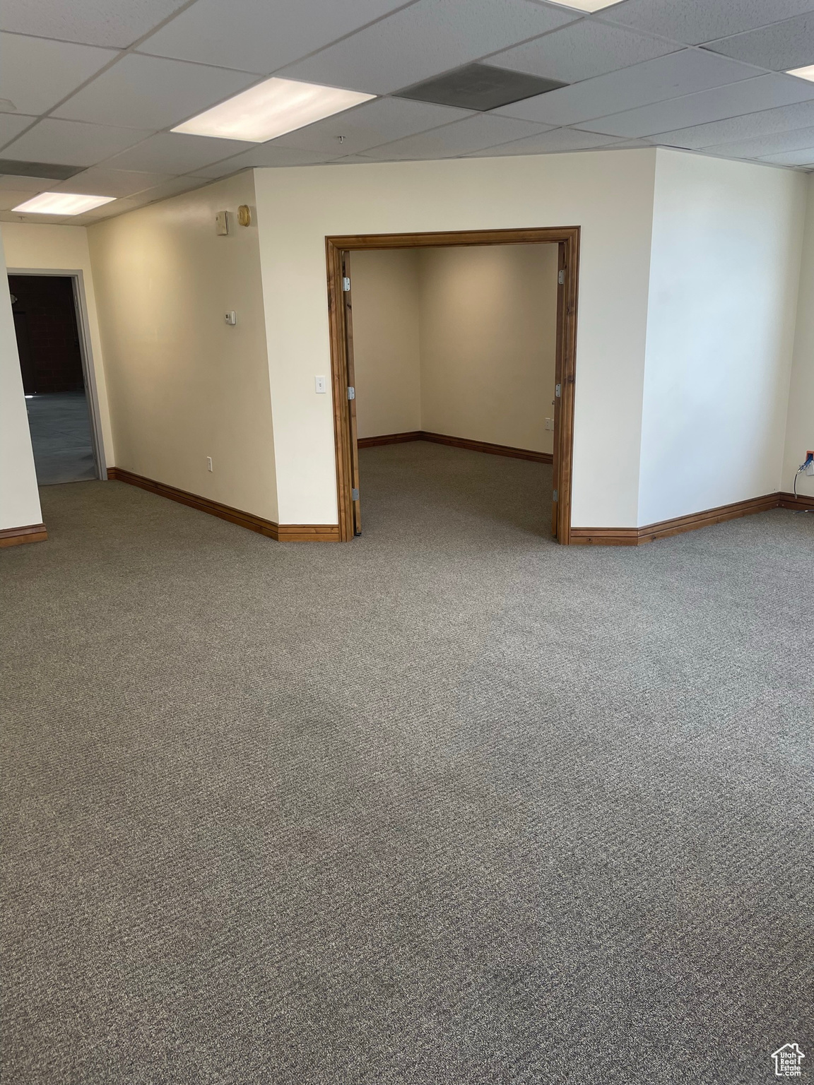 Spare room with light colored carpet and a paneled ceiling