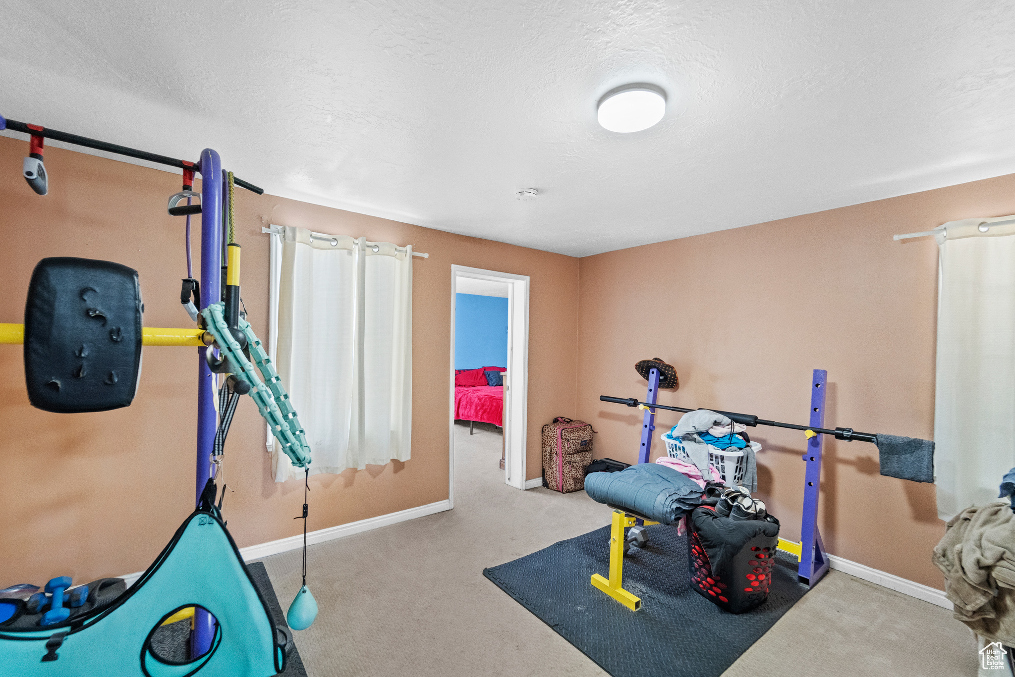 Exercise room with carpet flooring and a textured ceiling