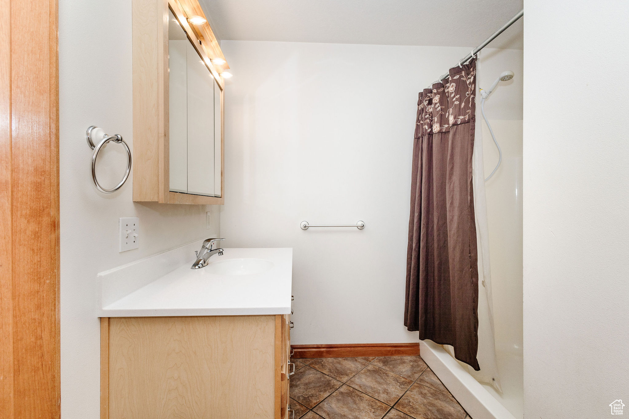 Bathroom featuring walk in shower, tile flooring, and cultured marble vanity.