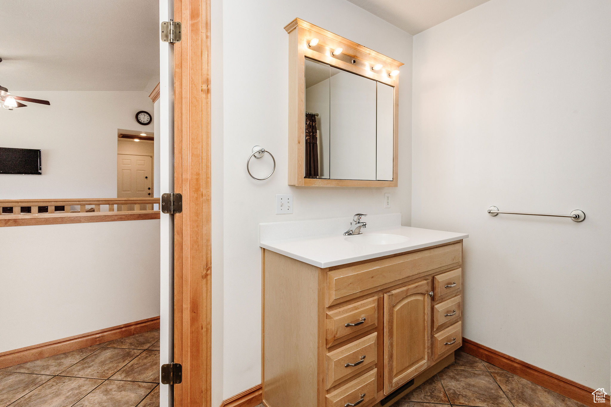 Bathroom featuring vaulted ceiling, oversized vanity, ceiling fan, and tile floors