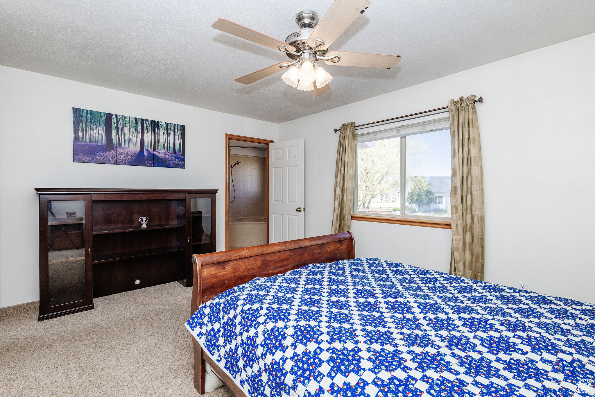 Owner's Suite Bedroom featuring light colored carpet, ceiling fan, and a textured ceiling