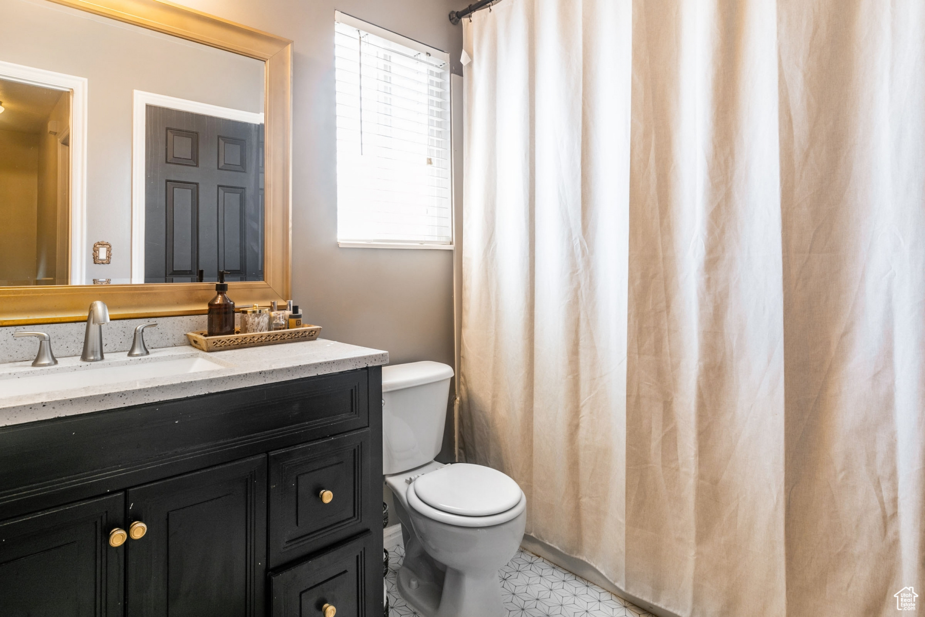 Bathroom with a healthy amount of sunlight, large vanity, tile floors, and toilet