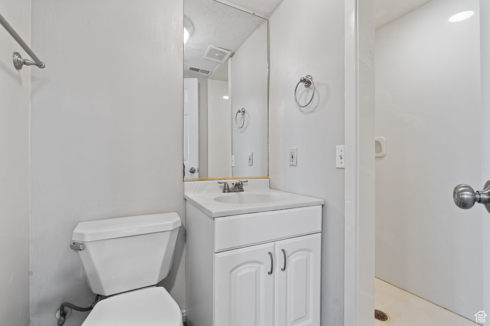 Bathroom featuring oversized vanity, toilet, and walk in shower