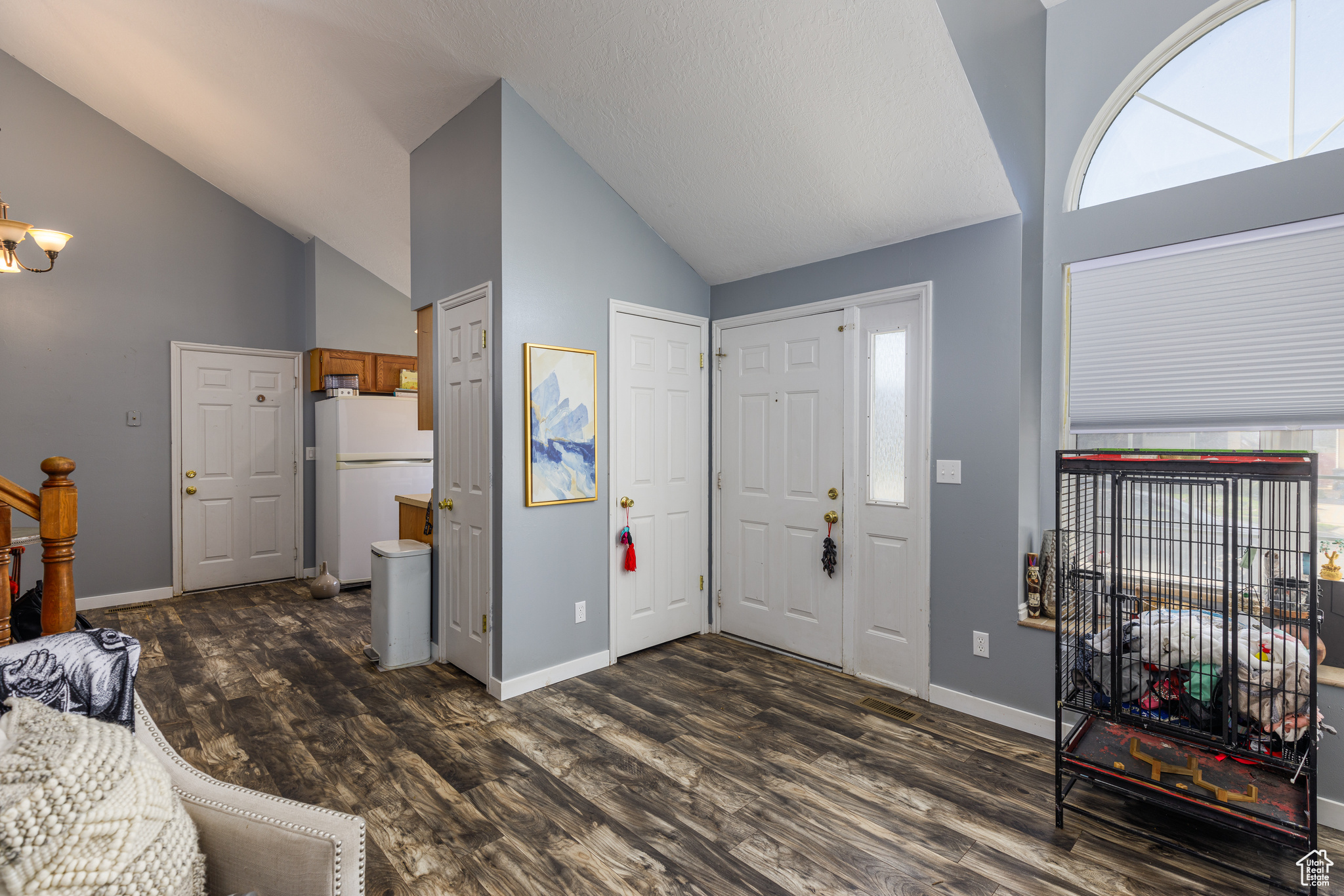 Entrance foyer with high vaulted ceiling and dark hardwood / wood-style floors