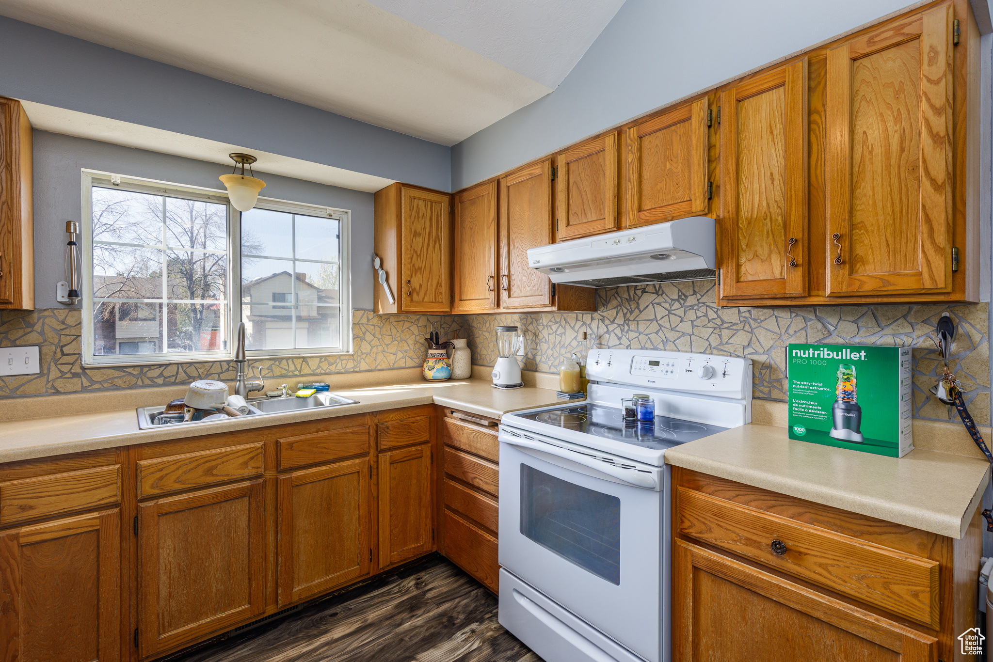 Kitchen featuring dark hardwood / wood-style floors, tasteful backsplash, white electric range, and sink