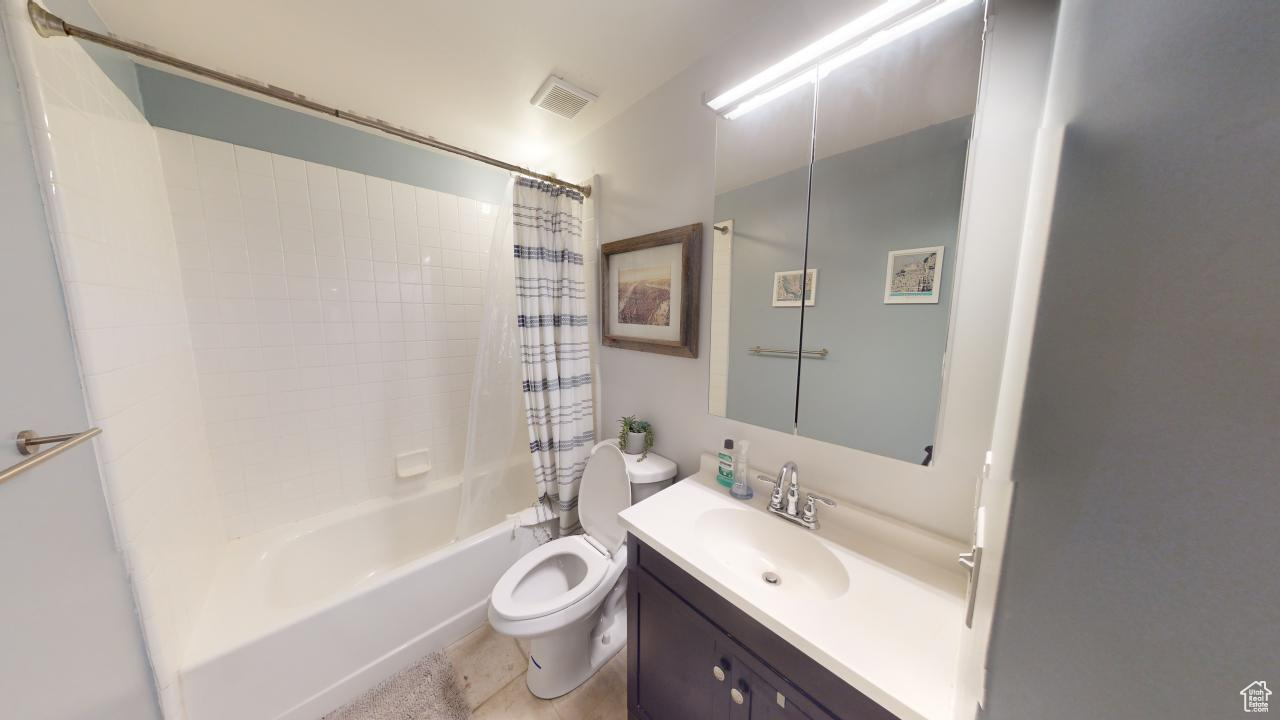 Full bathroom featuring shower / bath combo, toilet, tile flooring, and vanity