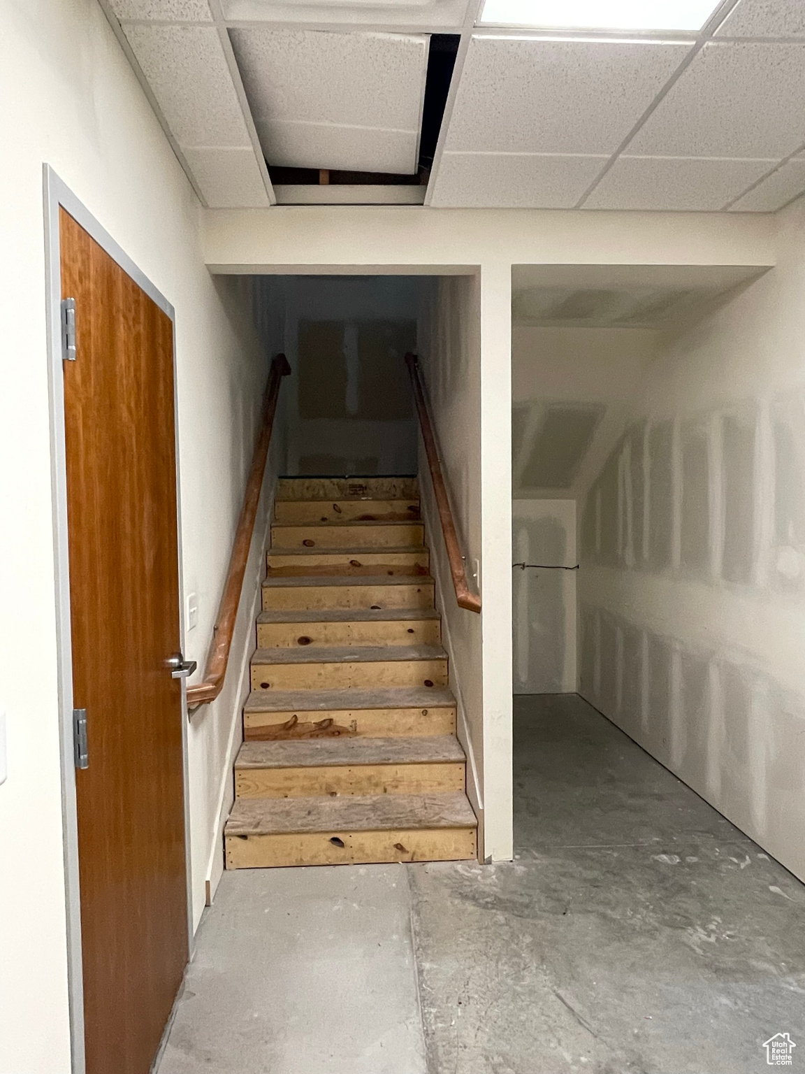 Stairs with a drop ceiling and concrete floors