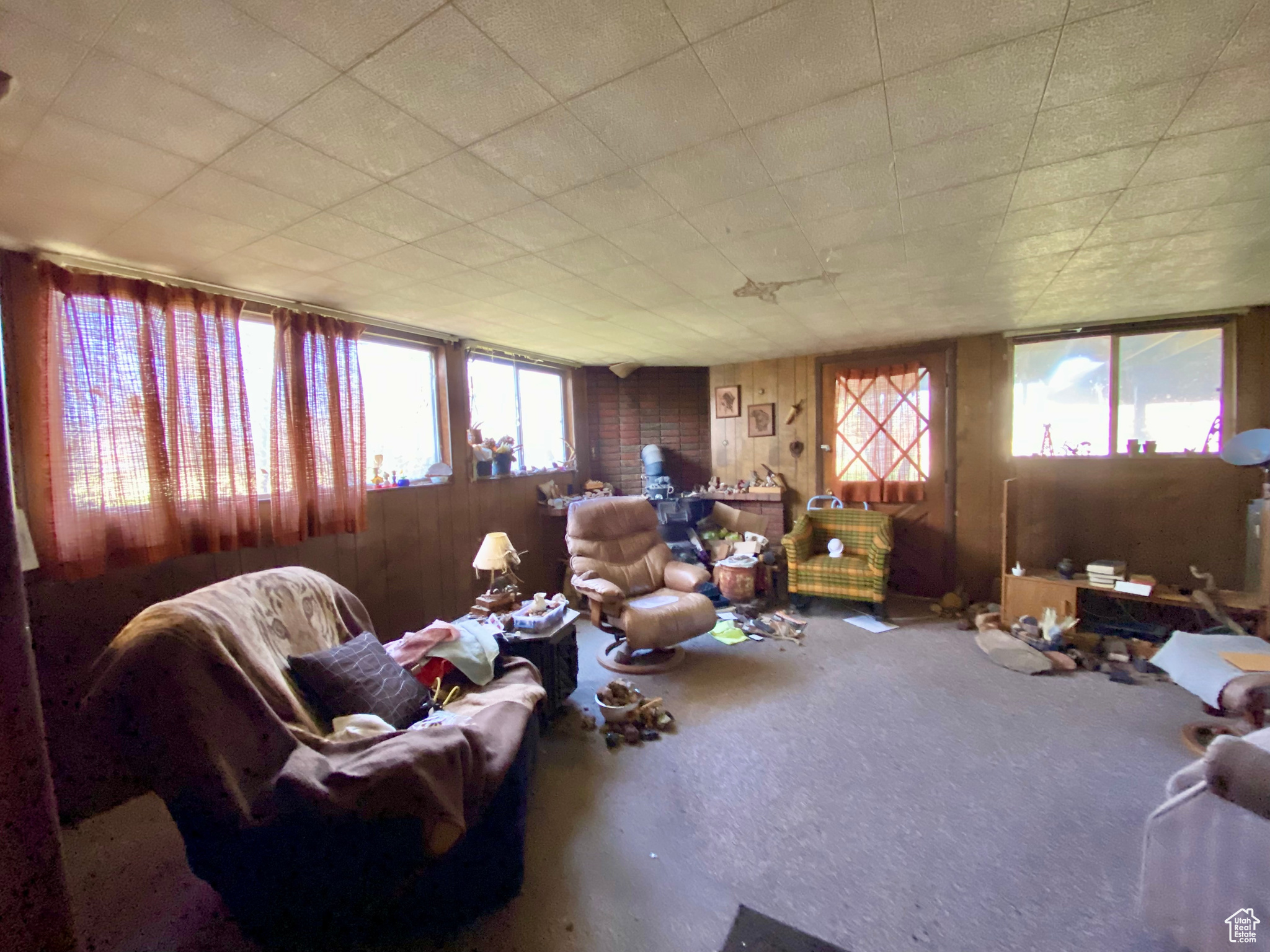 Living room with wood walls and a wealth of natural light