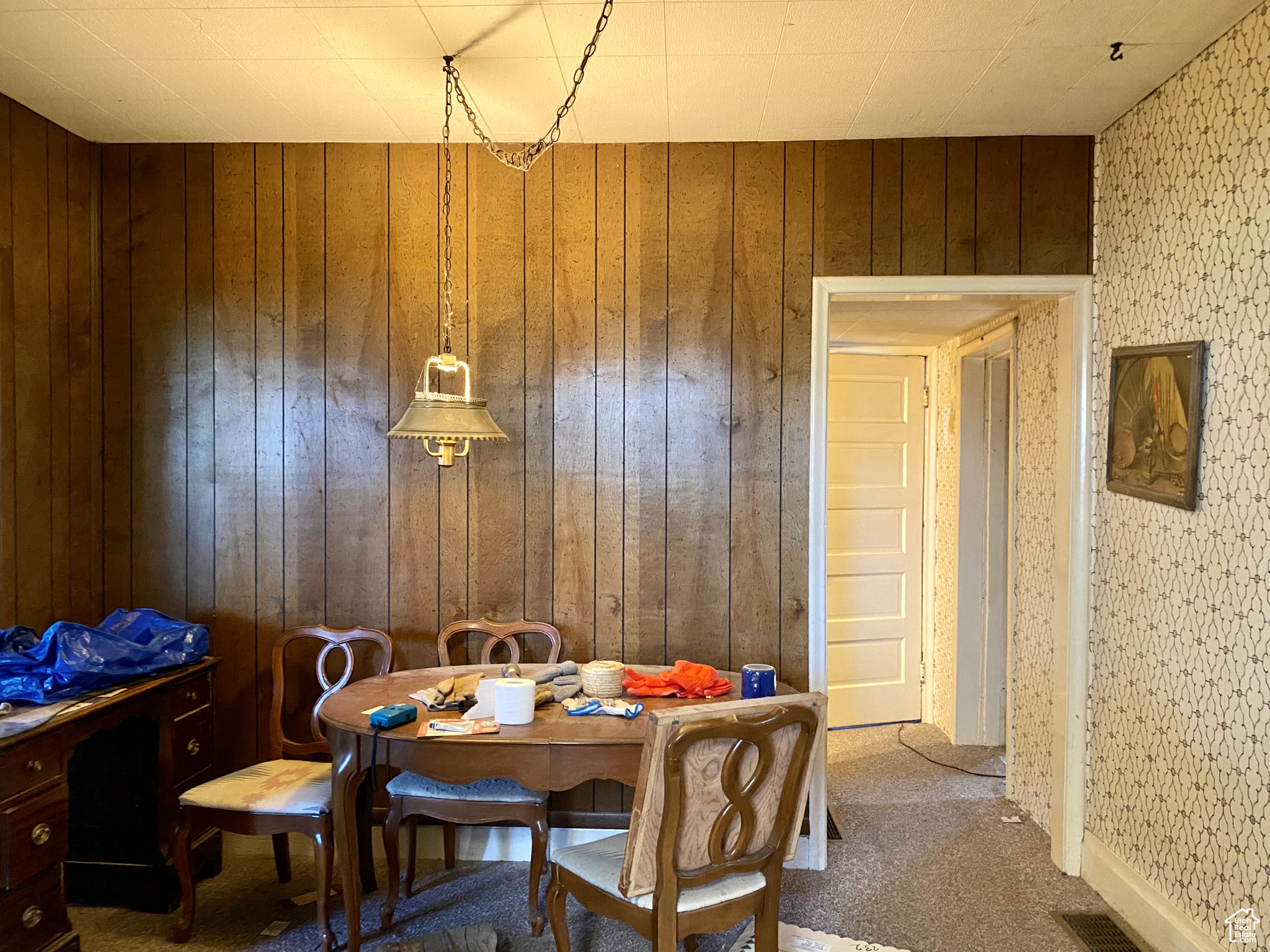 Carpeted dining space with wood walls