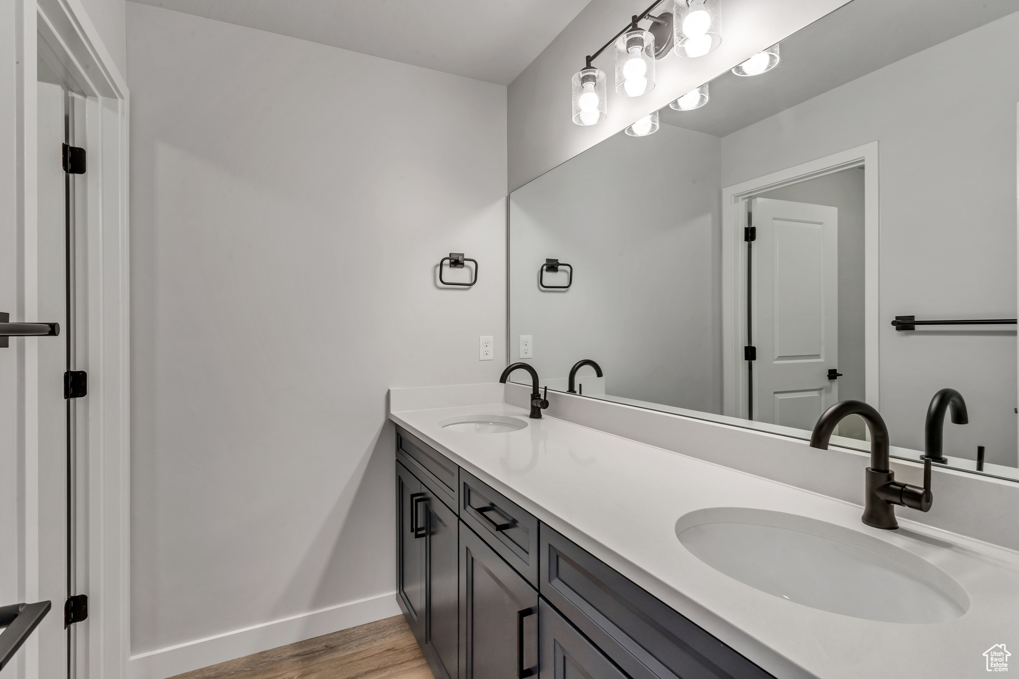 PHOTOS FROM A SIMILAR HOME. COLORS AND SELECTIONS WILL VARY.  Bathroom 2 featuring oversized vanity, hardwood / wood-style flooring, and double sink