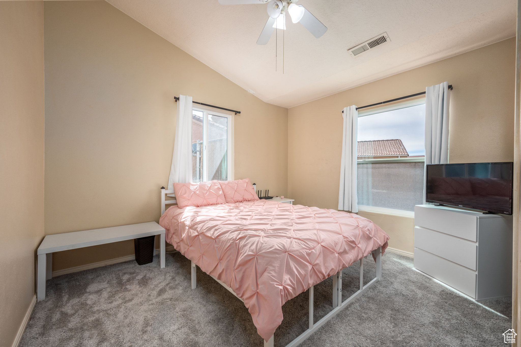 Bedroom with vaulted ceiling, ceiling fan, and dark carpet