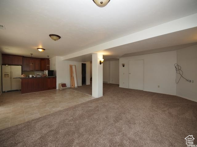 Lower level living room with light carpet