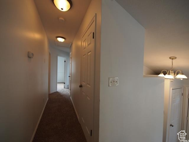 Upstairs  hallway featuring dark carpet