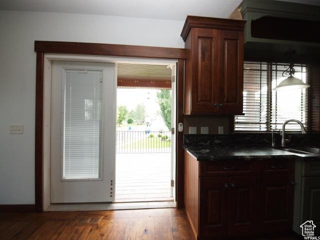Upstairs  Kitchen featuring sink, dark stone countertops, and dark hardwood / wood-style floors