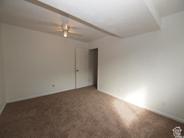Lower level bedroom featuring ceiling fan and carpet