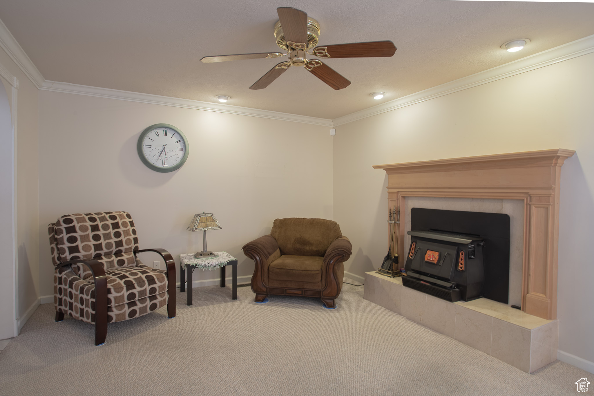 Sitting room featuring ceiling fan, light carpet, and ornamental molding
