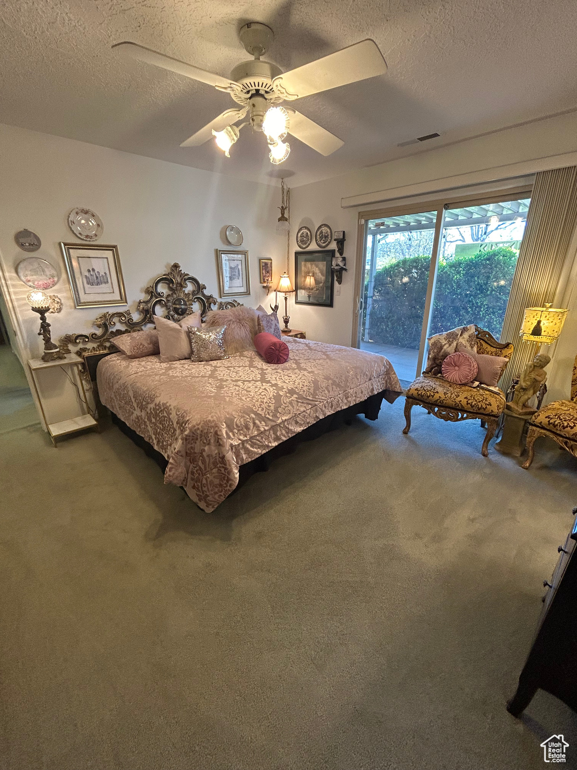 Carpeted bedroom featuring ceiling fan, access to exterior, and a textured ceiling